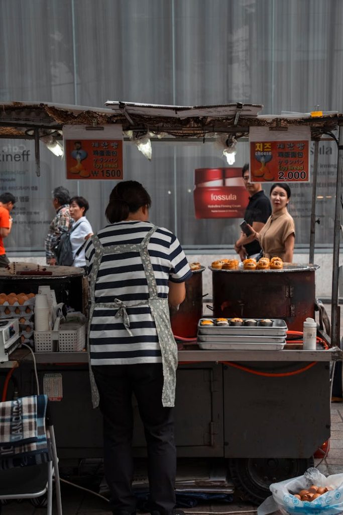 pexels photo 18936019 Back view of a street vendor preparing food at an outdoor stall in Seoul.