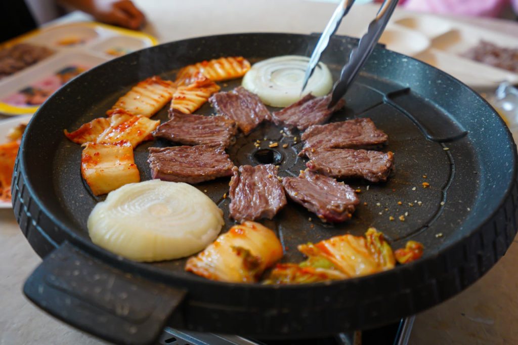 pexels photo 5785545 Delicious Korean barbecue featuring beef, onions, and kimchi. Perfect for food lovers.